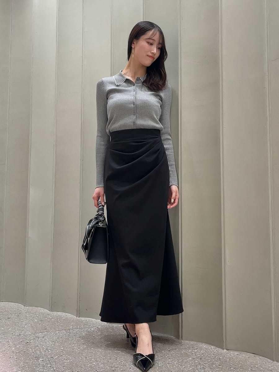 ホワイト系のトレンチコート、ブラック系のスカート、ブラック系のパンプスを着用したレディースの冬コーディネートの6枚目の写真