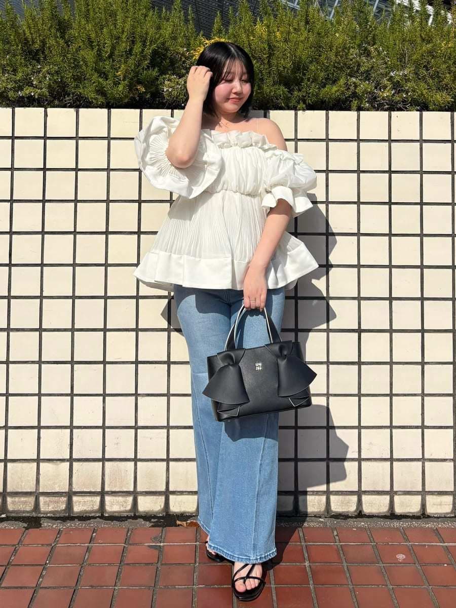 ブルー系のデニムパンツ、ホワイト系のその他トップス、ブラック系のハンドバッグを着用したレディースの春コーディネートの3枚目の写真