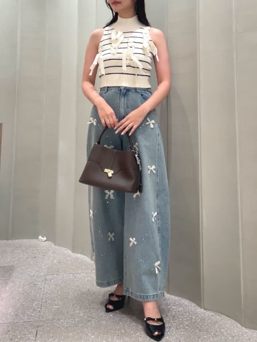 ブラウン系のハンドバッグ、ブルー系のその他パンツ、その他のニット/セーターを着用したレディースの夏コーディネートの3枚目の写真