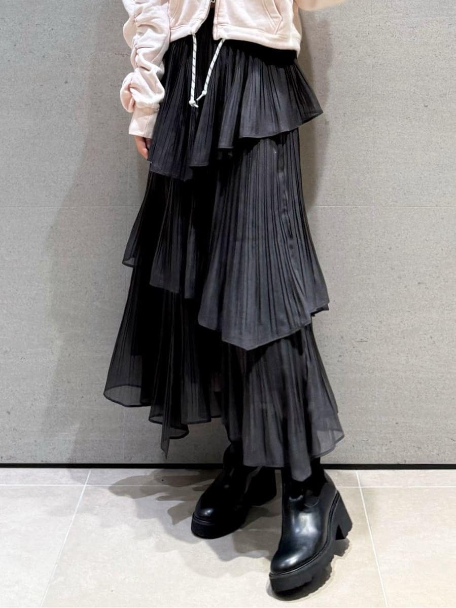 グレー系のスカート、ピンク系のスウェット、その他のイヤリングを着用したレディースの秋コーディネートの5枚目の写真