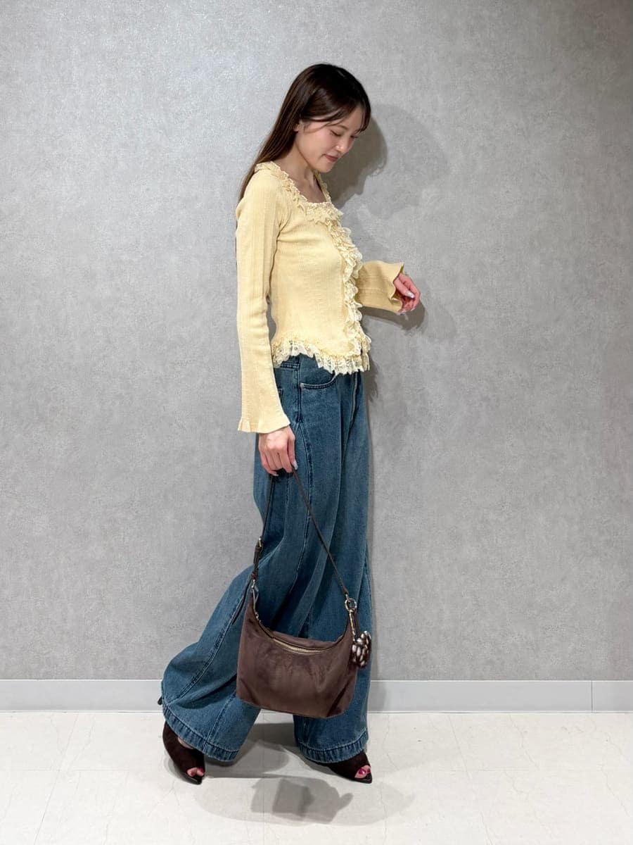 ブルー系のデニムパンツ、イエロー系のニット/セーター、ブラウン系のサンダルを着用したレディースの夏コーディネートの3枚目の写真