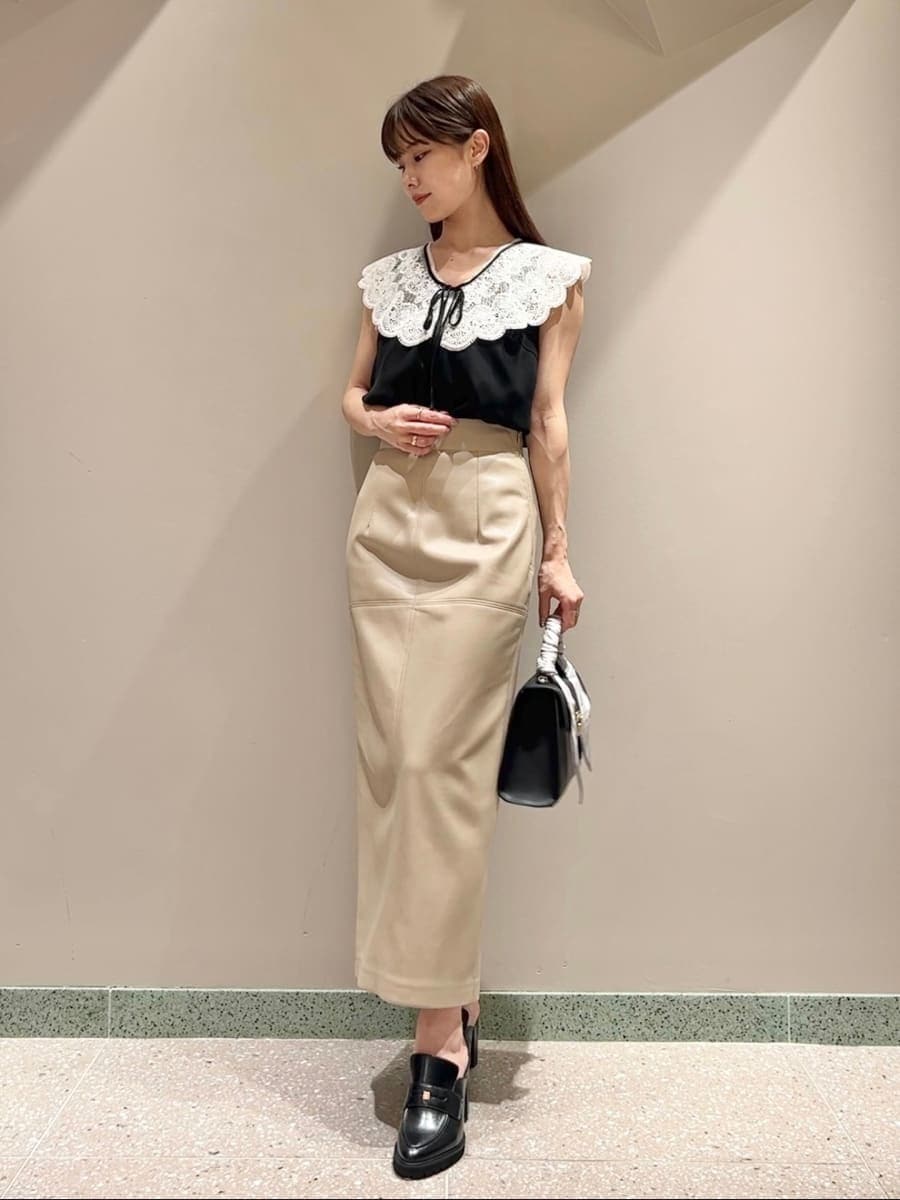 ブラック系のシャツ/ブラウス、ホワイト系のスカート、ブラック系のハンドバッグを着用したレディースの夏コーディネートの2枚目の写真