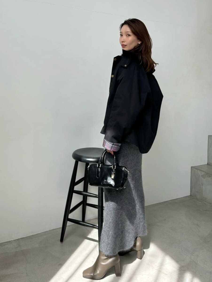 ブラック系のブルゾン、ブラック系のボストンバッグ、グレー系のワンピースを着用したレディースの秋コーディネートの6枚目の写真