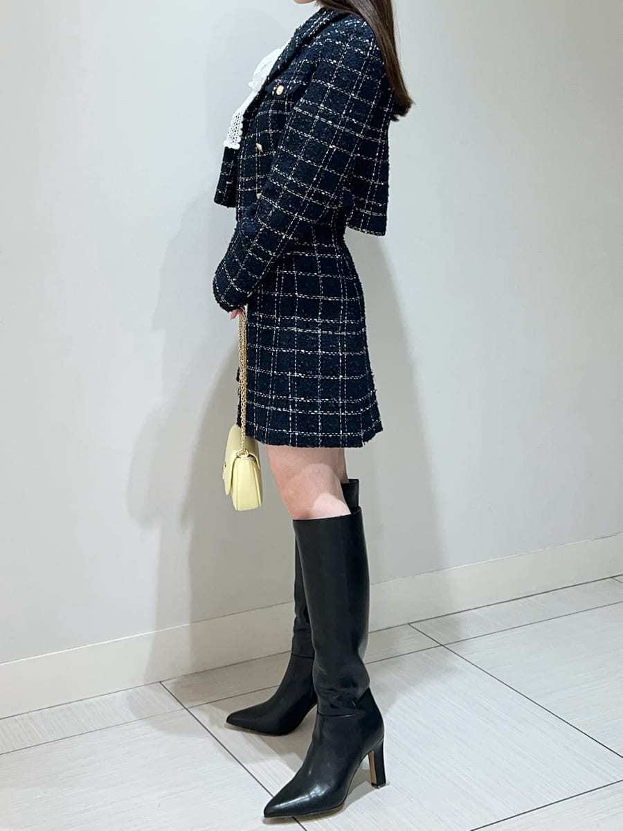 ブラック系のブーツ、ブルー系のテーラードジャケット、ブルー系のスカートを着用したレディースの春コーディネートの4枚目の写真