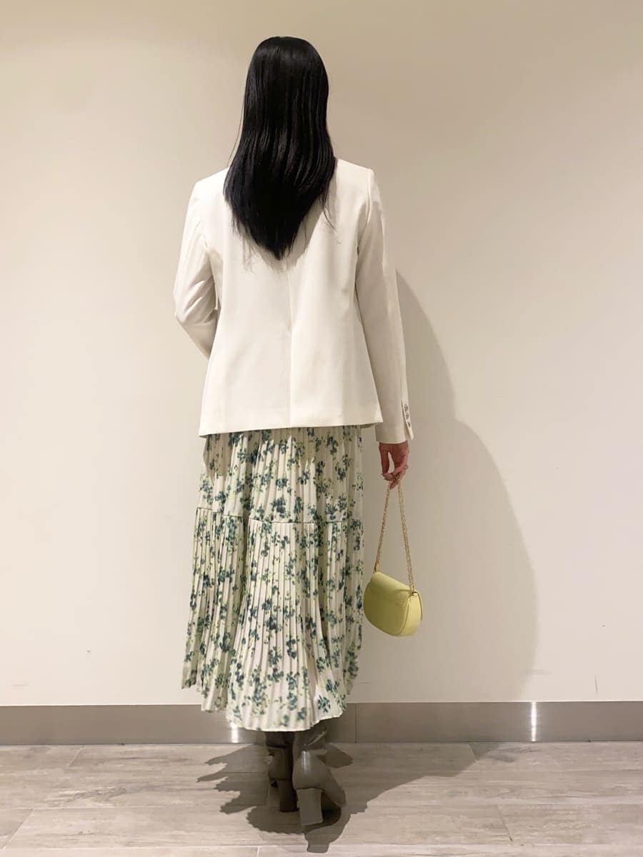 グリーン系のワンピース、ホワイト系のテーラードジャケット、イエロー系のショルダーバッグを着用したレディースの冬コーディネートの3枚目の写真