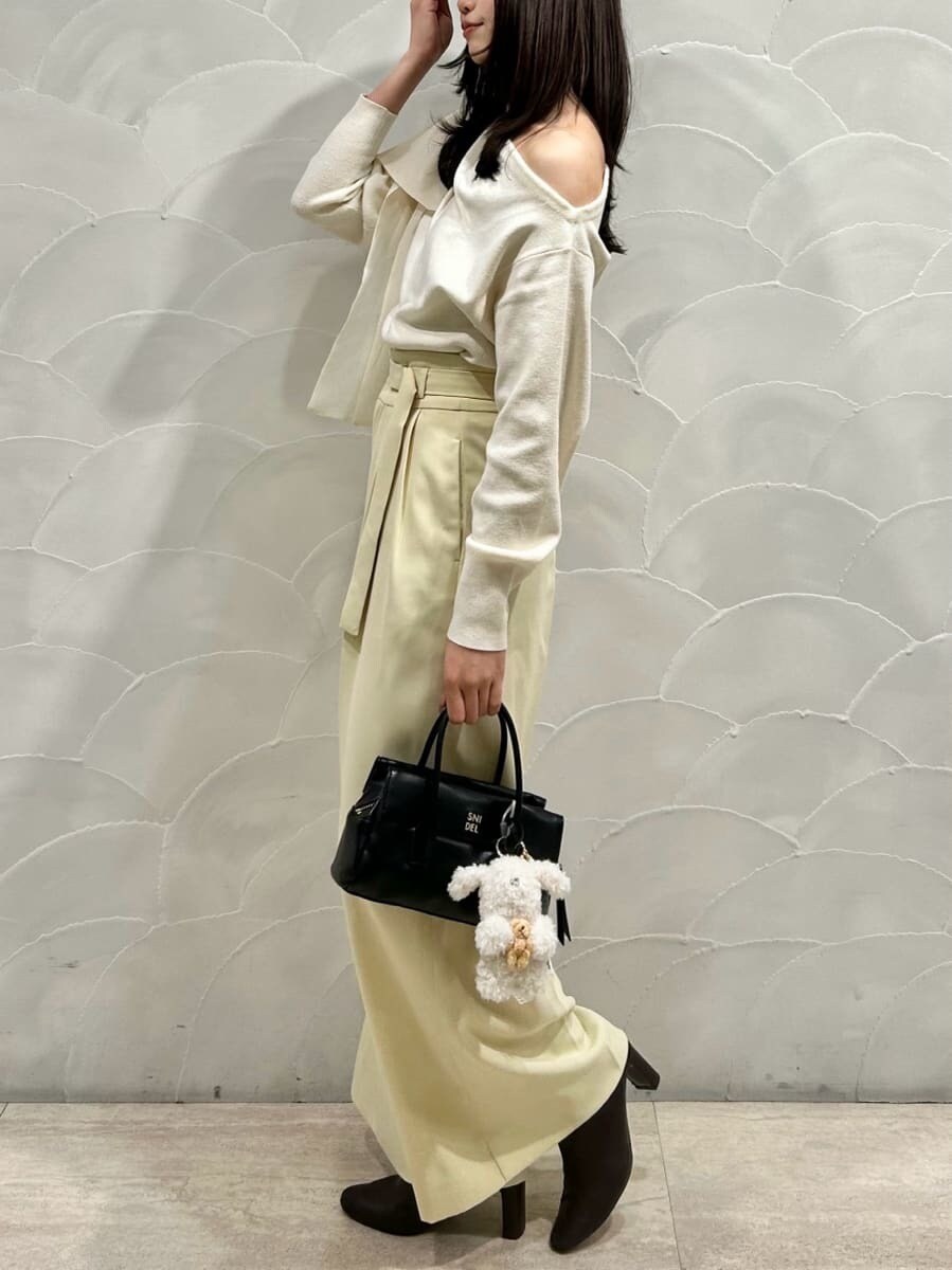 レッド系のブーツ、ホワイト系のニット/セーター、ブラック系のボストンバッグを着用したレディースの秋コーディネートの2枚目の写真