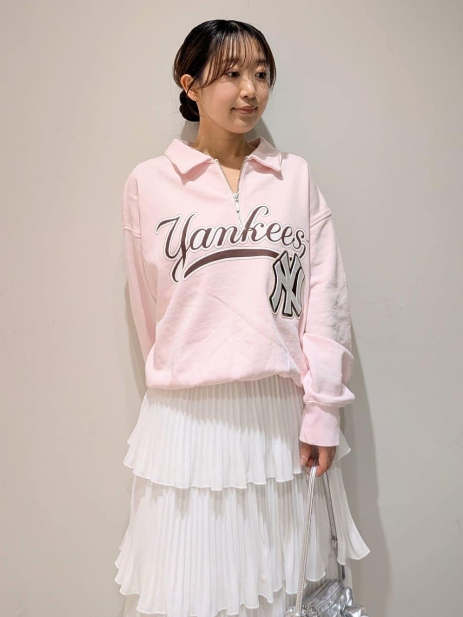 ホワイト系のスカート、ピンク系のスウェット、シルバー系のハンドバッグを着用したレディースの春コーディネートの3枚目の写真