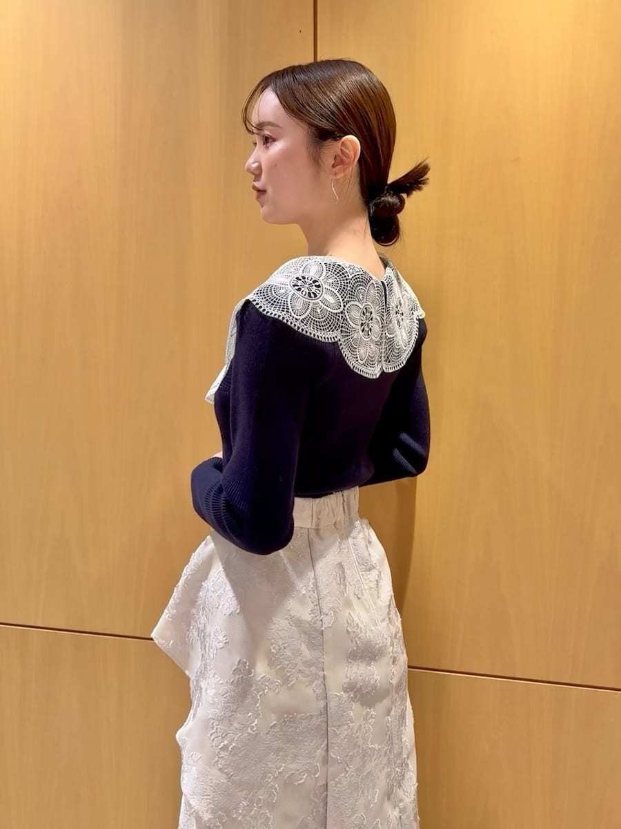 ブルー系のニット/セーター、ブラック系のハンドバッグ、ホワイト系のチャームを着用したレディースの冬コーディネートの5枚目の写真