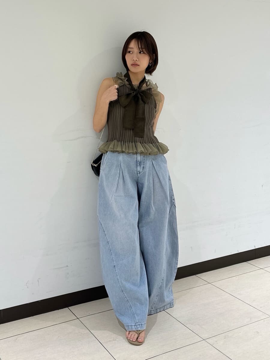 ブラック系のショルダーバッグ、ブルー系のデニムパンツ、グリーン系のニット/セーターを着用したレディースの夏コーディネートの2枚目の写真