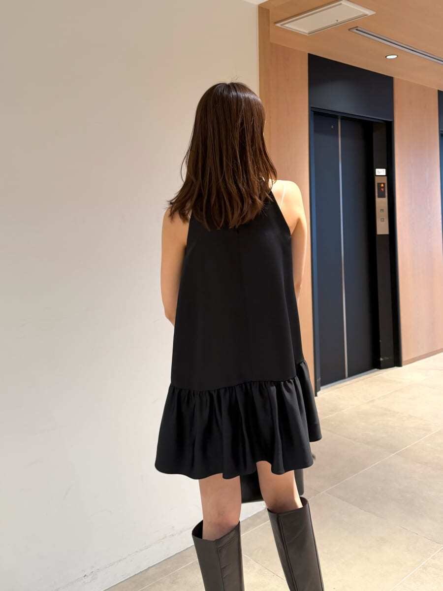 グレー系のブーツ、ブラック系のワンピース、ブラック系のボストンバッグを着用したレディースの秋コーディネートの6枚目の写真