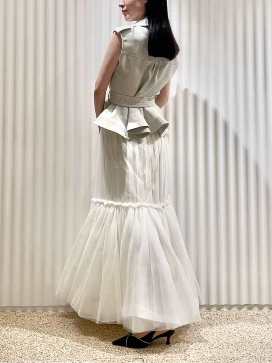 グレー系のワンピース、ブラック系のパンプス、ホワイト系のショルダーバッグを着用したレディースの春コーディネートの3枚目の写真