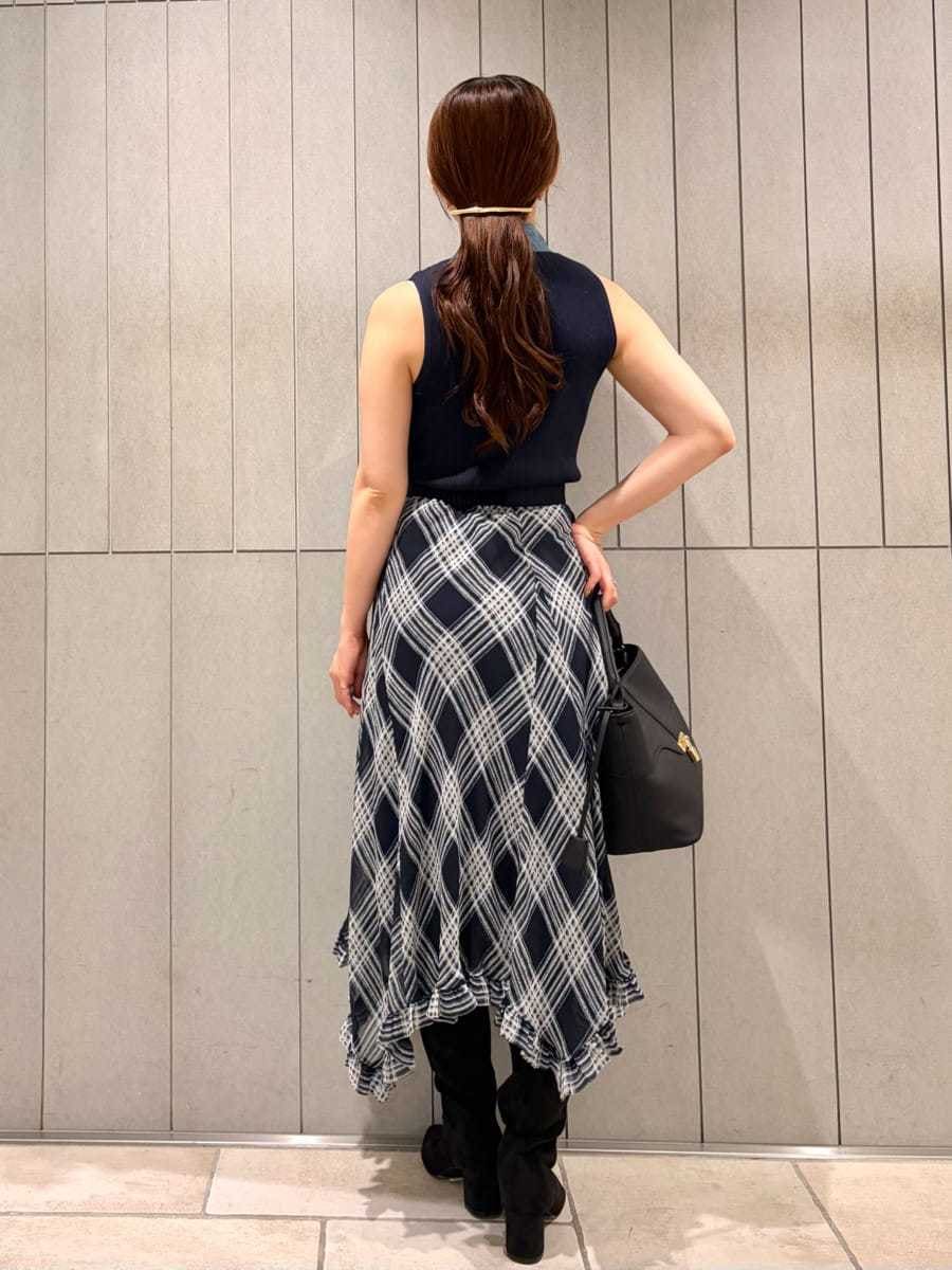 ブラック系のハンドバッグ、ブルー系のスカート、ブルー系のTシャツ/カットソーを着用したレディースの夏コーディネートの2枚目の写真