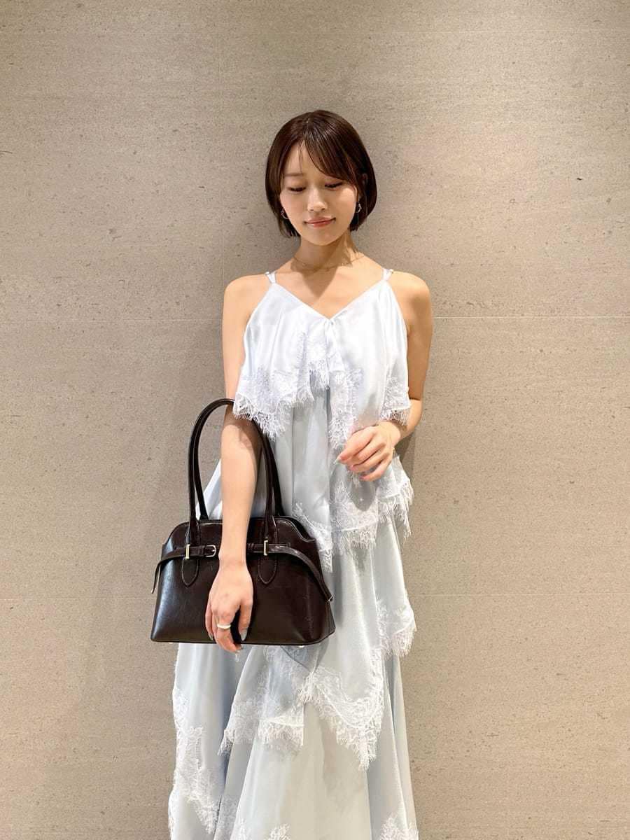 ブルー系のワンピース、ブラウン系のブーツ、ブラウン系のボストンバッグを着用したレディースの夏コーディネートの7枚目の写真