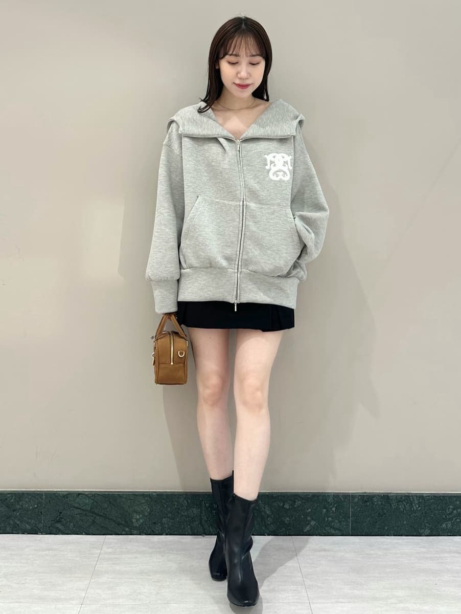 グレー系のパーカー、ブラック系のスカート、ブラック系のブーツを着用したレディースの夏コーディネートの2枚目の写真