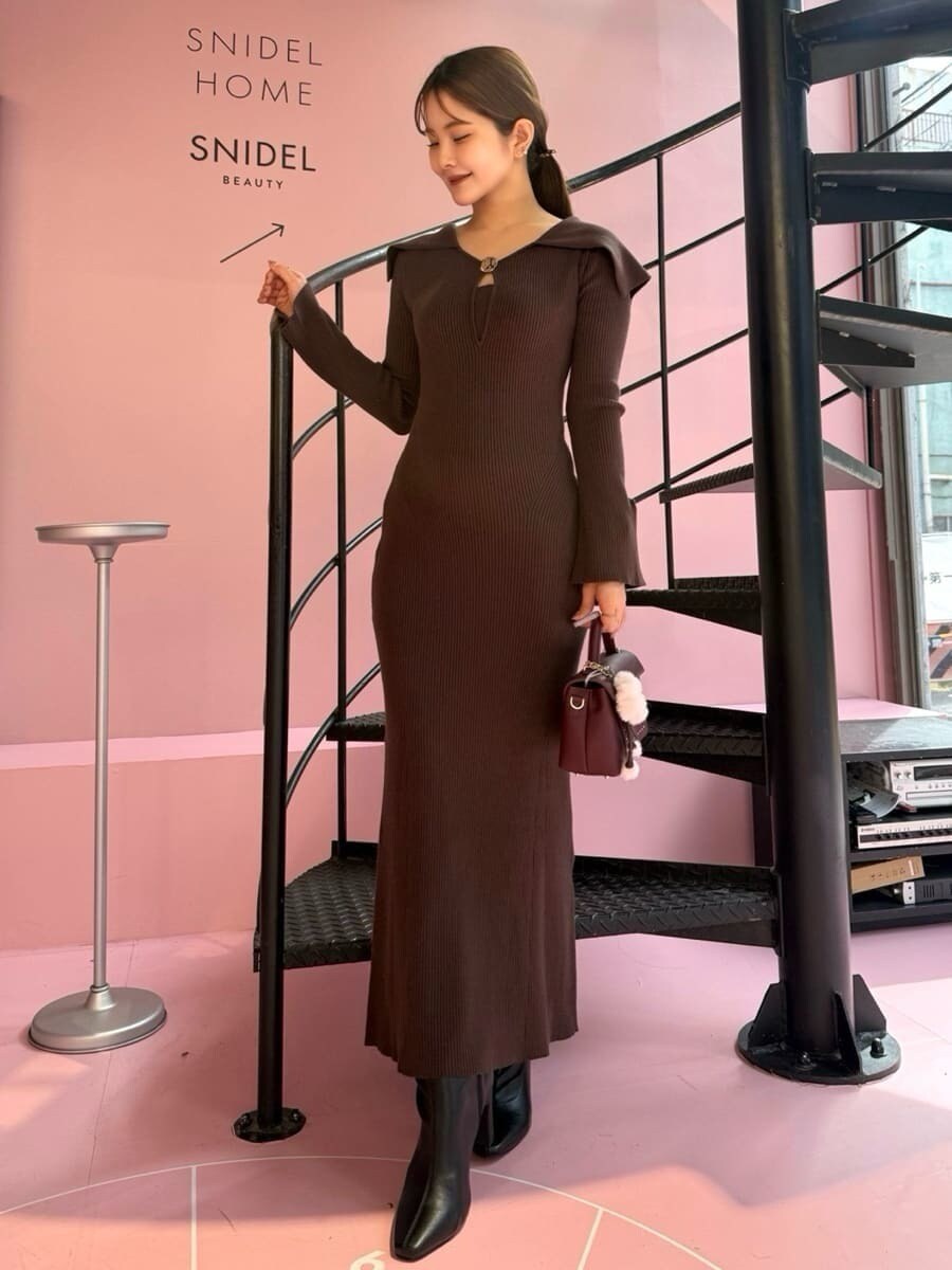 ブラック系のブルゾン、ブラウン系のワンピース、ブラック系のブーツを着用したレディースの秋コーディネートの6枚目の写真