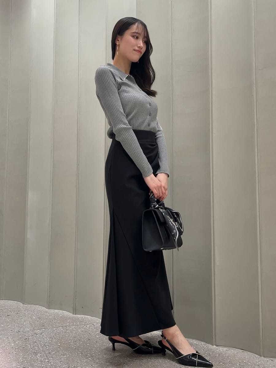 ホワイト系のトレンチコート、ブラック系のスカート、ブラック系のパンプスを着用したレディースの冬コーディネートの7枚目の写真