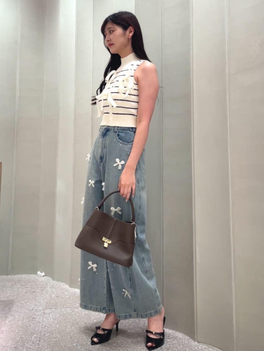 ブラウン系のハンドバッグ、ブルー系のその他パンツ、その他のニット/セーターを着用したレディースの夏コーディネートの2枚目の写真