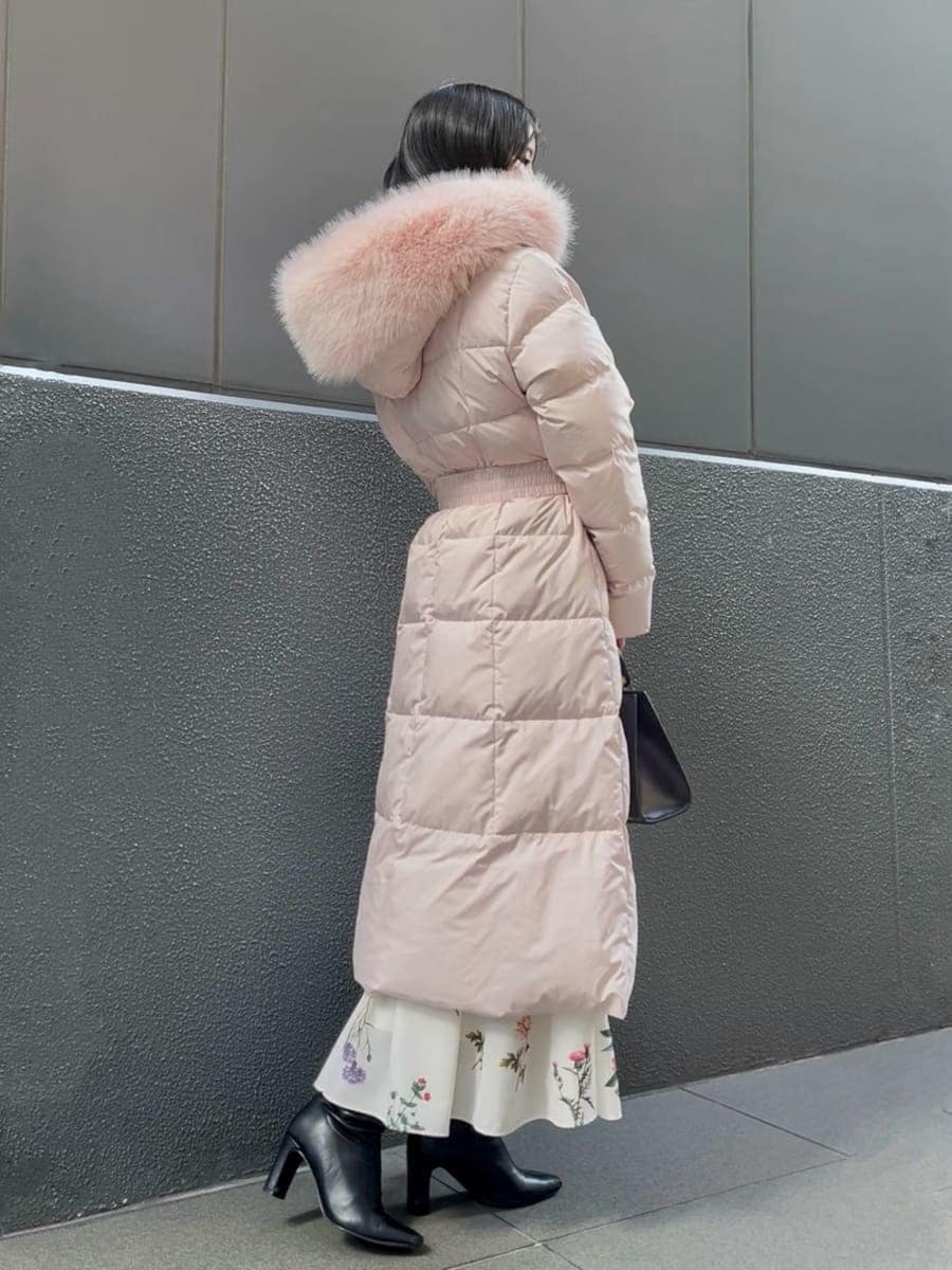 ブラック系のブーツ、ピンク系のダウンジャケット/コート、ブラック系のハンドバッグを着用したレディースの冬コーディネートの4枚目の写真