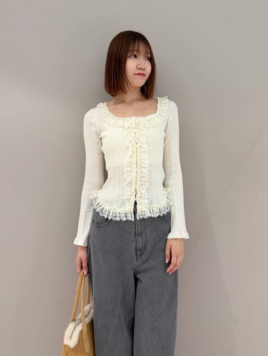 グレー系のデニムパンツ、ホワイト系のニット/セーター、ブラック系のブーツを着用したレディースの夏コーディネートの4枚目の写真