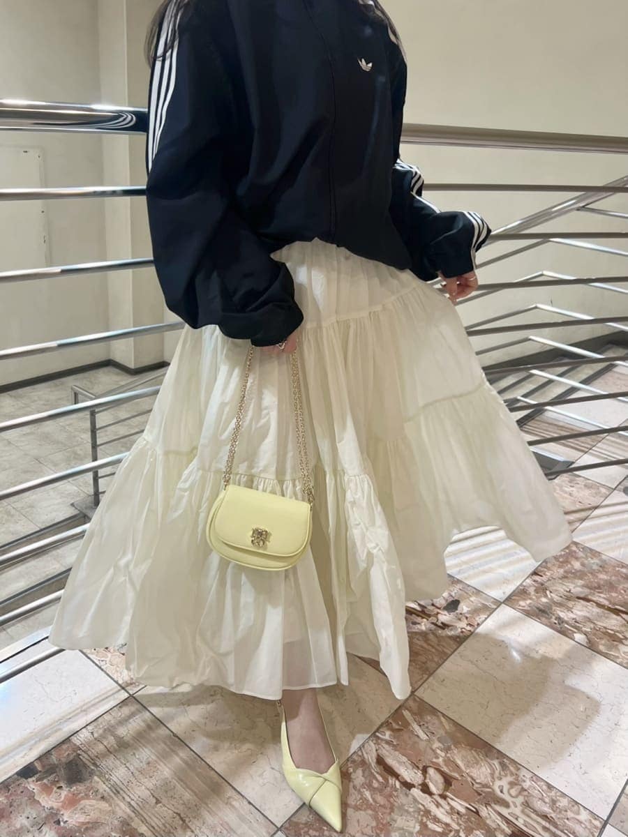 ホワイト系のスカート、ブラック系のブルゾン、イエロー系のパンプスを着用したレディースの春コーディネートの6枚目の写真