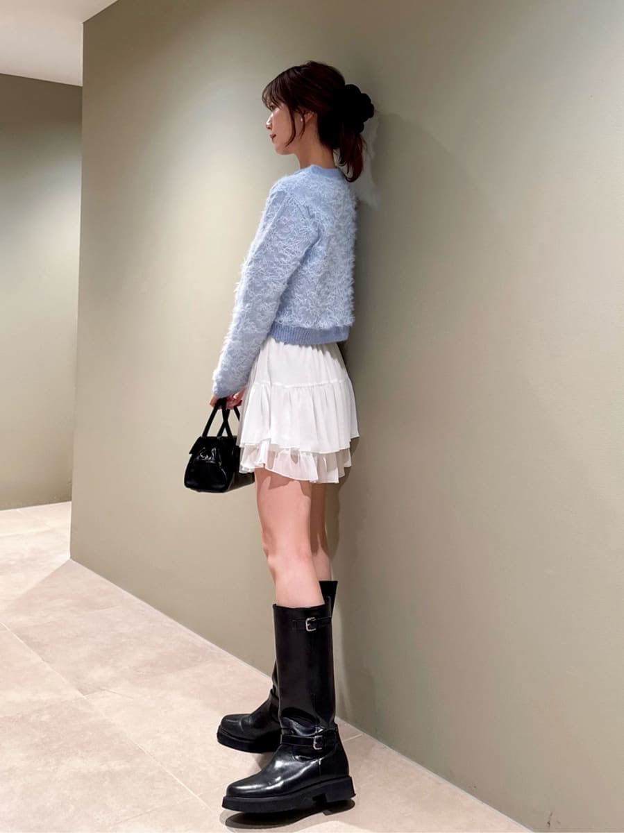 ブラック系のブーツ、ホワイト系のその他パンツ、ブルー系のカーディガン/ボレロを着用したレディースの冬コーディネートの2枚目の写真