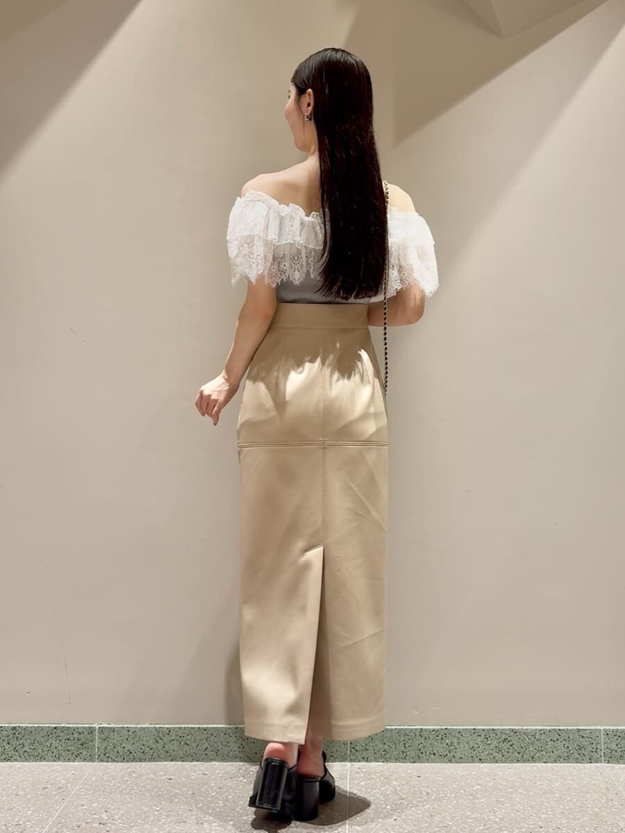 グリーン系のニット/セーター、ホワイト系のスカート、ブラック系のローファーを着用したレディースの夏コーディネートの3枚目の写真