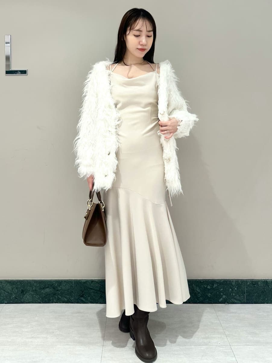 ホワイト系のワンピース、ホワイト系のカーディガン/ボレロ、ブラウン系のハンドバッグを着用したレディースの秋コーディネートの2枚目の写真