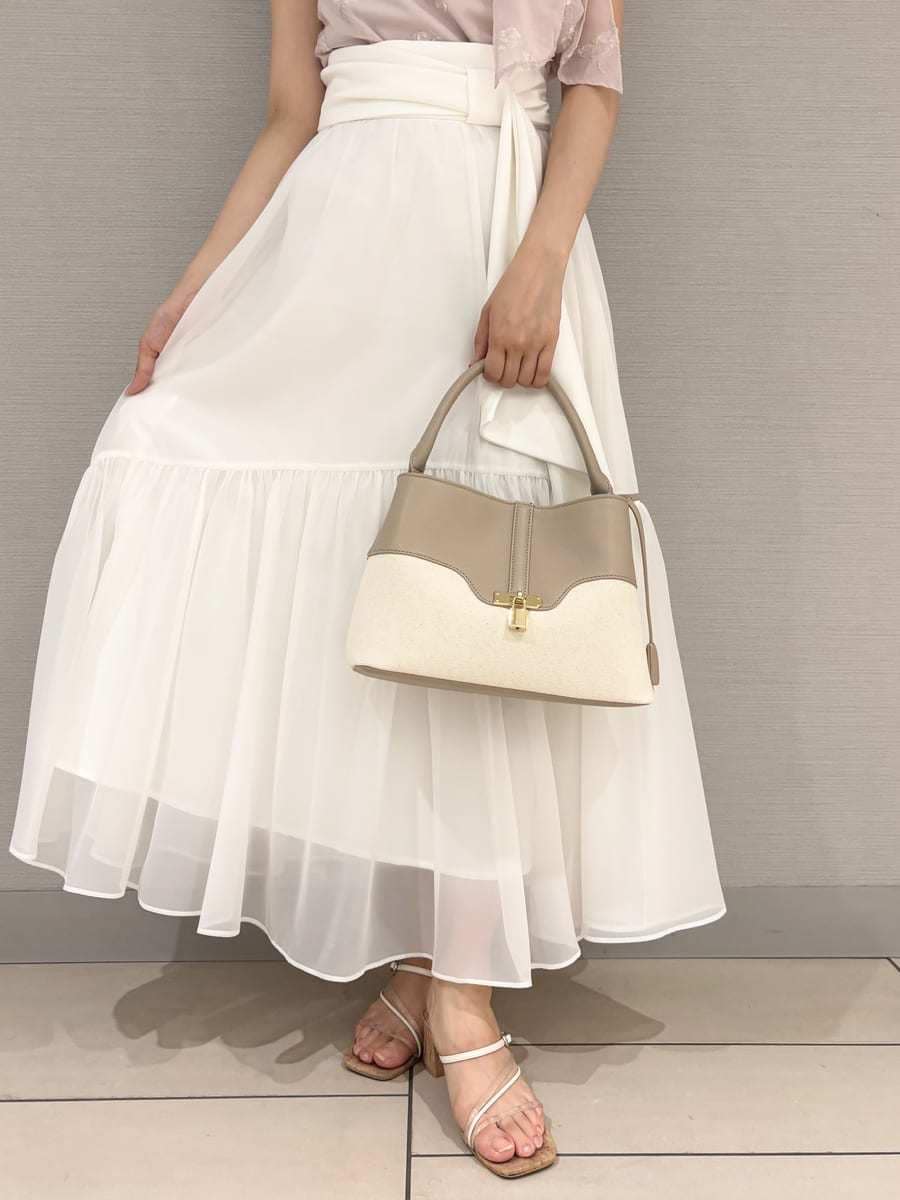 ベージュ系のハンドバッグ、ホワイト系のスカート、その他のサンダルを着用したレディースの夏コーディネートの7枚目の写真