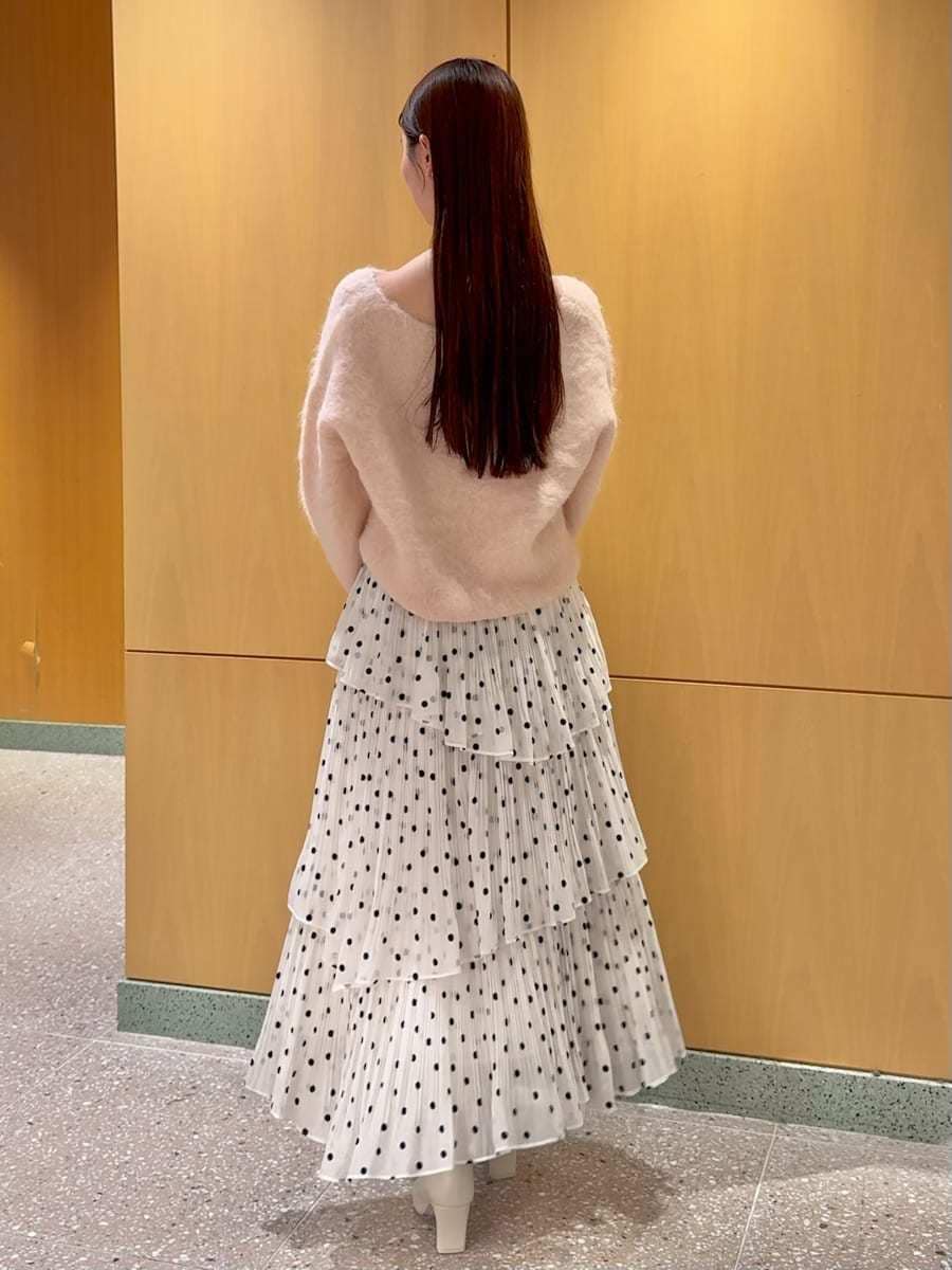 ピンク系のニット/セーター、その他のスカート、ピンク系のハンドバッグを着用したレディースの秋コーディネートの3枚目の写真