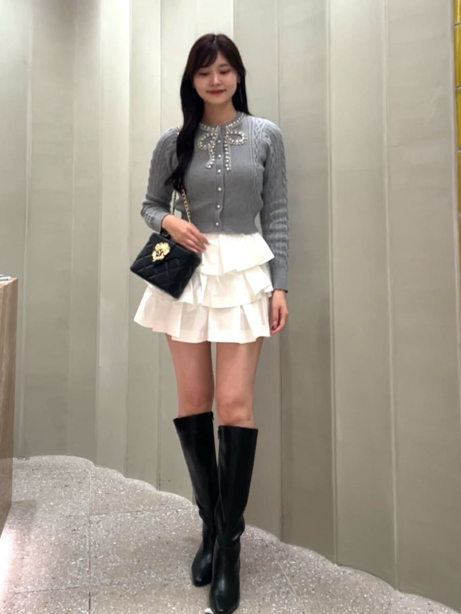 ホワイト系のその他パンツ、グレー系のニット/セーター、ブラック系のブーツを着用したレディースの秋コーディネートの2枚目の写真