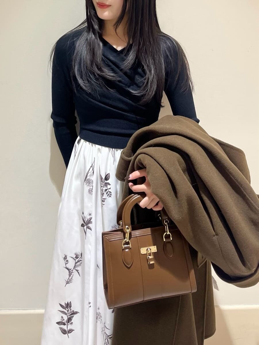 ブラック系のブーツ、ブラウン系のハンドバッグ、ブラウン系のチェスターコートを着用したレディースの冬コーディネートの5枚目の写真