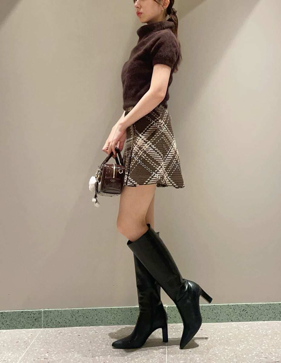 ブラウン系のスカート、ブラウン系のニット/セーター、ブラウン系のボストンバッグを着用したレディースの秋コーディネートの2枚目の写真
