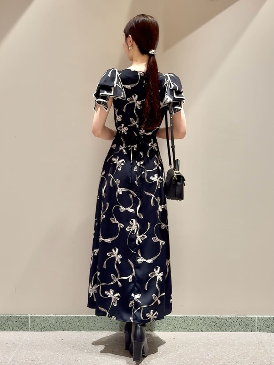 ブルー系のワンピース、ブラック系のブーツ、ブラック系のショルダーバッグを着用したレディースの秋コーディネートの3枚目の写真