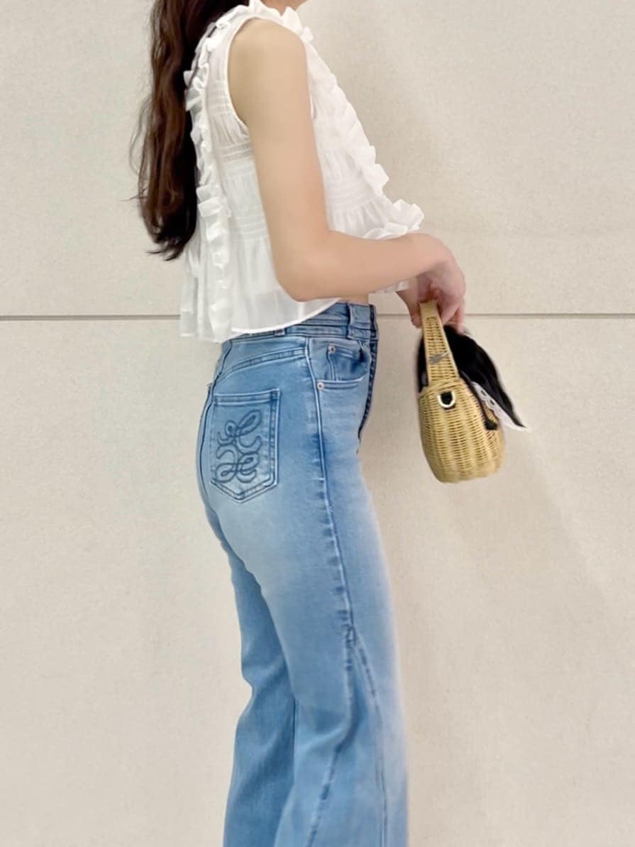 ブルー系のデニムパンツ、ブラック系のかごバッグ、ホワイト系のシャツ/ブラウスを着用したレディースの夏コーディネートの6枚目の写真