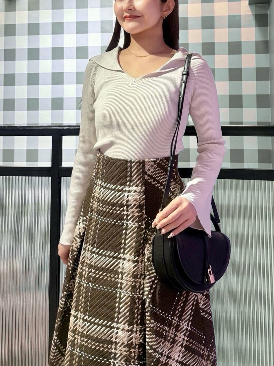 ホワイト系のニット/セーター、ブラウン系のスカート、レッド系のブーツを着用したレディースの秋コーディネートの5枚目の写真