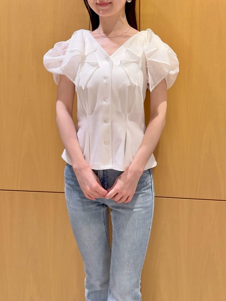 ブルー系のデニムパンツ、ホワイト系のTシャツ/カットソー、ブラウン系のハンドバッグを着用したレディースの夏コーディネートの4枚目の写真