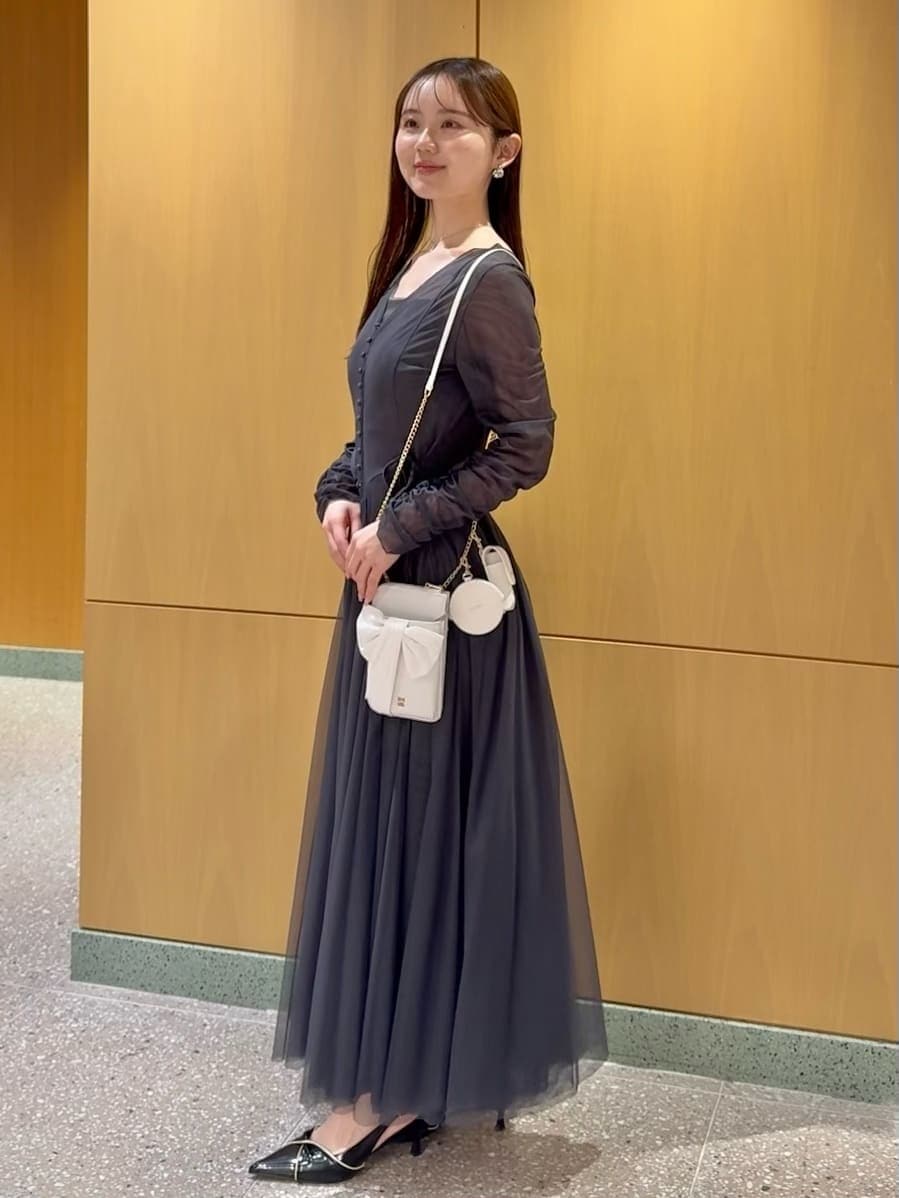 ブラック系のパンプス、ホワイト系のショルダーバッグ、シルバー系のネックレスを着用したレディースの冬コーディネートの2枚目の写真