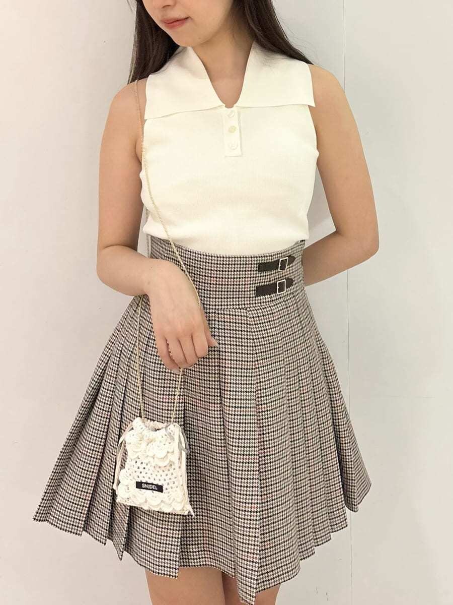 ホワイト系のニット/セーター、ベージュ系のスカート、ホワイト系のチャームを着用したレディースの夏コーディネートの4枚目の写真