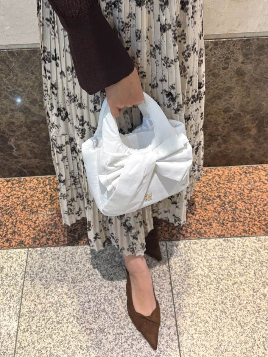 ベージュ系のワンピース、ホワイト系のカーディガン/ボレロ、ブラウン系のパンプスを着用したレディースの冬コーディネートの10枚目の写真