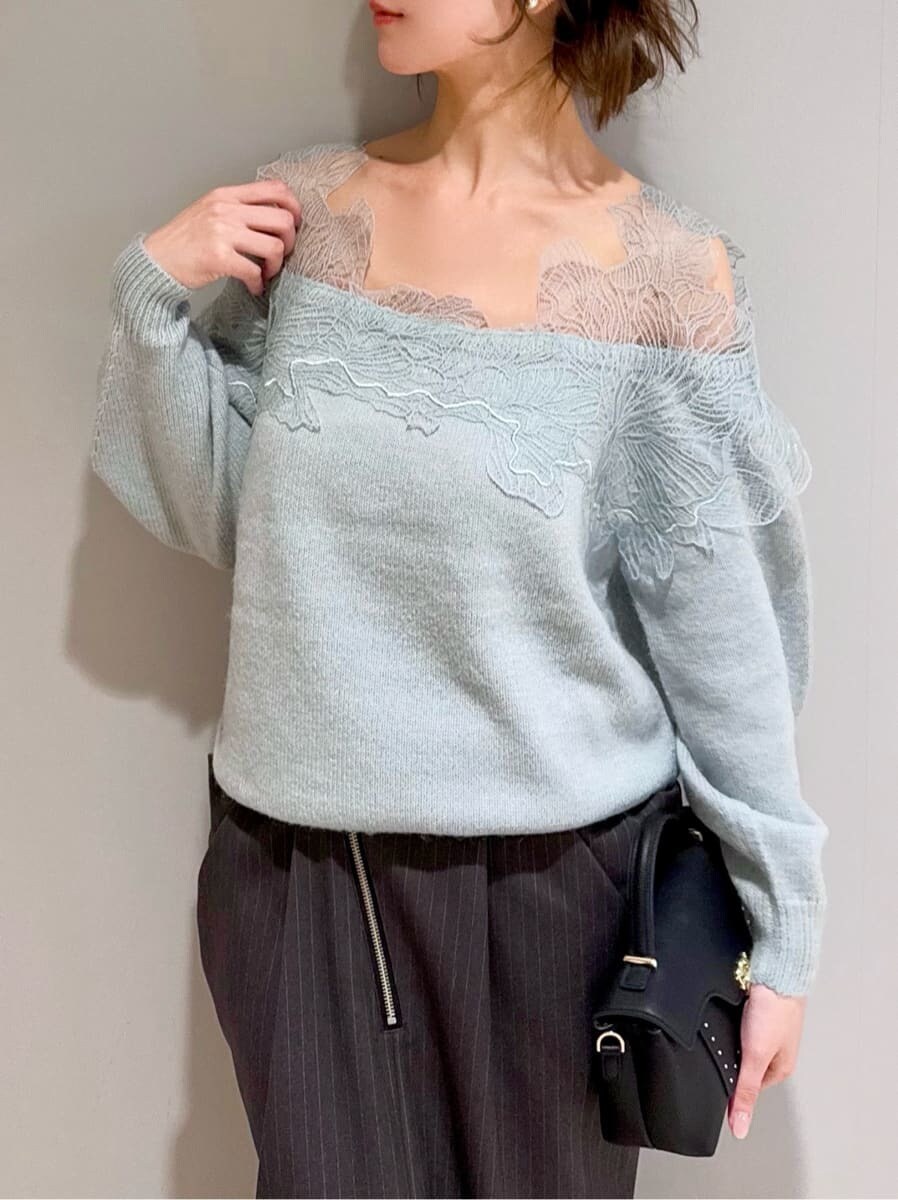 グリーン系のニット/セーター、グレー系のスカート、ブラック系のショルダーバッグを着用したレディースの秋コーディネートの3枚目の写真