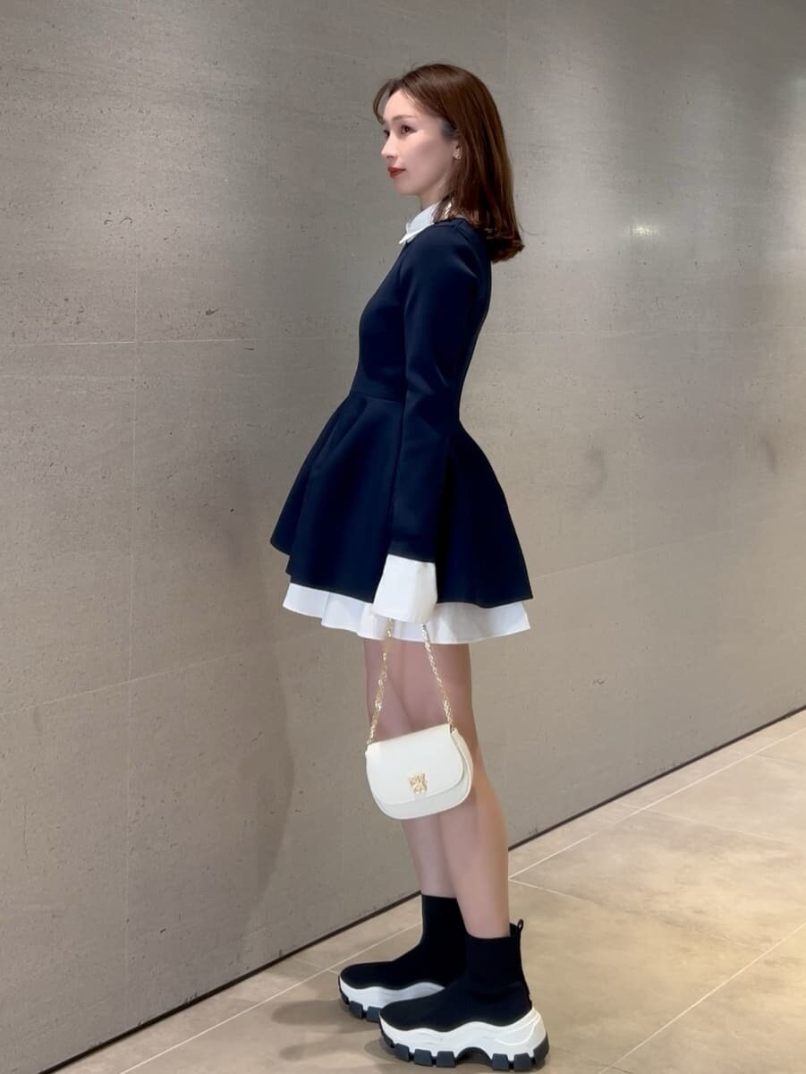 その他のブーツ、ブルー系のその他トップス、ホワイト系のショルダーバッグを着用したレディースの冬コーディネートの2枚目の写真