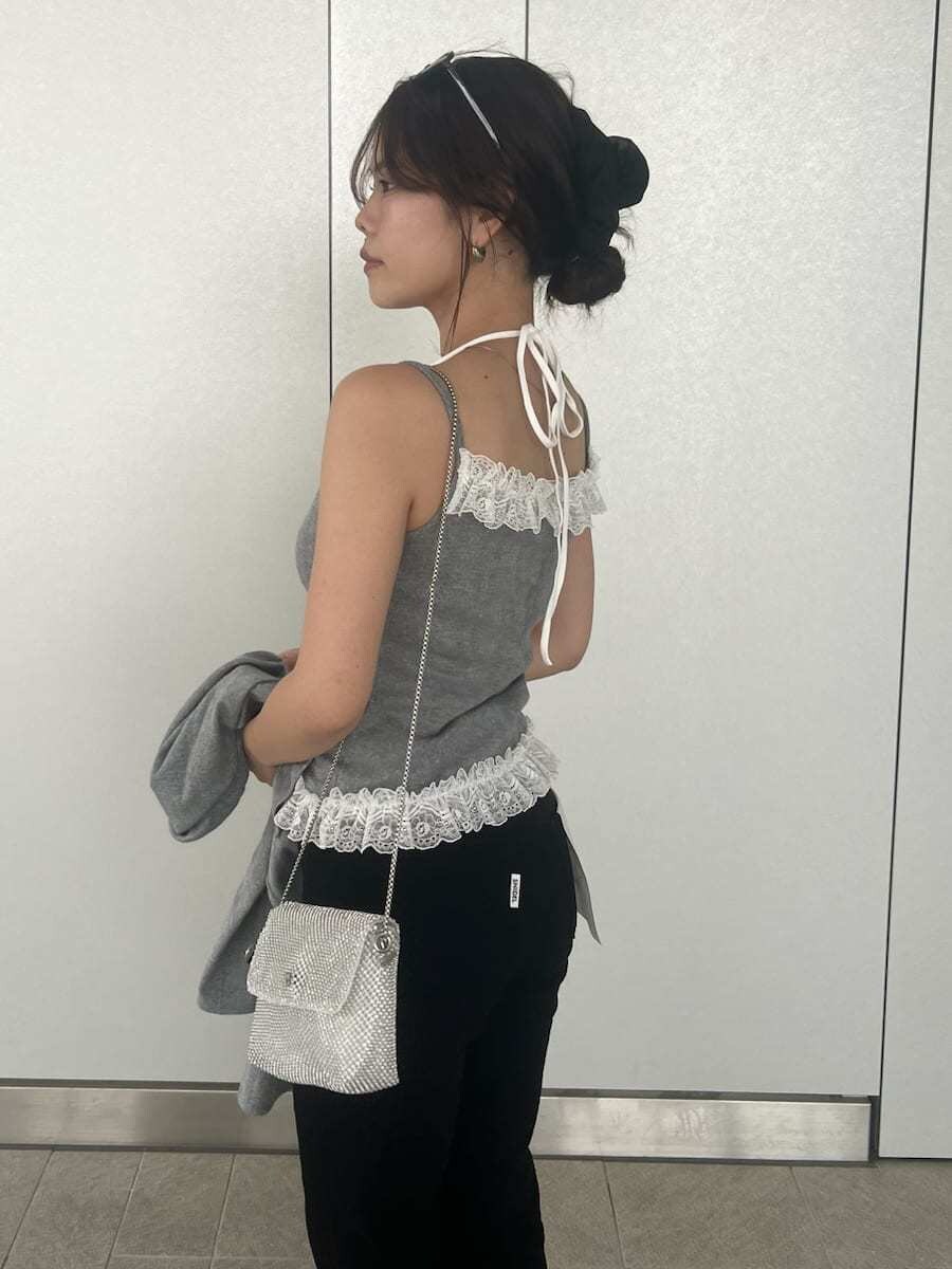 グレー系のキャミソール、グレー系のカーディガン/ボレロ、ブラック系のデニムパンツを着用したレディースの春コーディネートの10枚目の写真