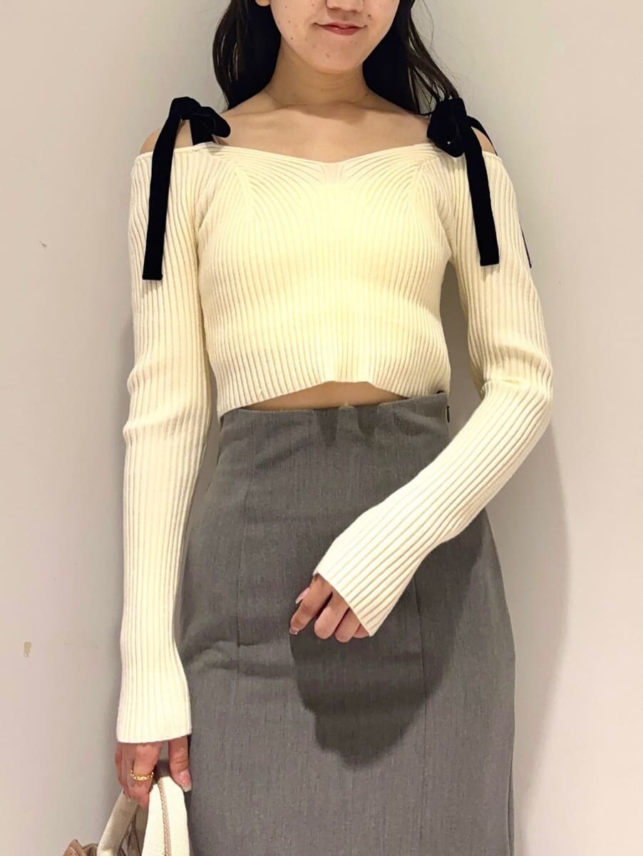 ホワイト系のニット/セーター、グレー系のスカート、ベージュ系のハンドバッグを着用したレディースの秋コーディネートの4枚目の写真