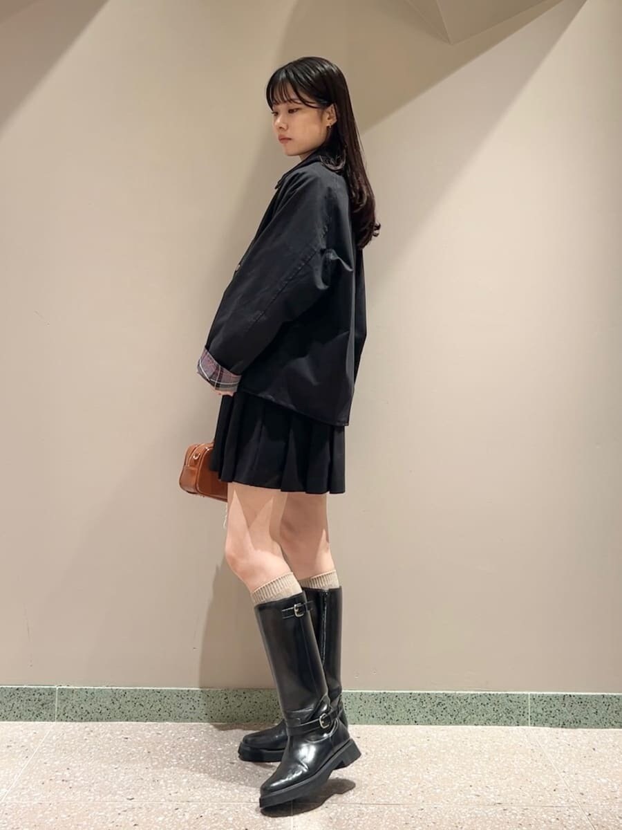 ブラック系のブルゾン、ブラック系のワンピース、ブラウン系のボストンバッグを着用したレディースの秋コーディネートの2枚目の写真