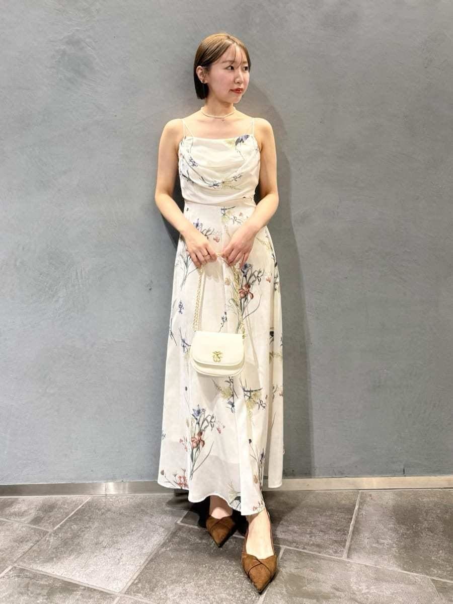 パープル系のパーカー、ホワイト系のワンピース、ブラウン系のパンプスを着用したレディースの冬コーディネートの3枚目の写真