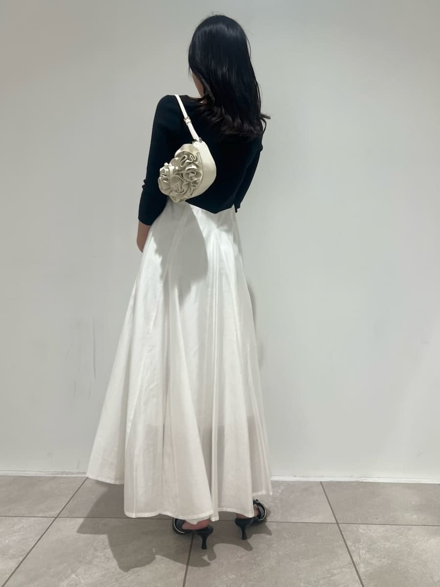 ブラック系のパンプス、ホワイト系のハンドバッグ、その他のワンピースを着用したレディースの冬コーディネートの3枚目の写真