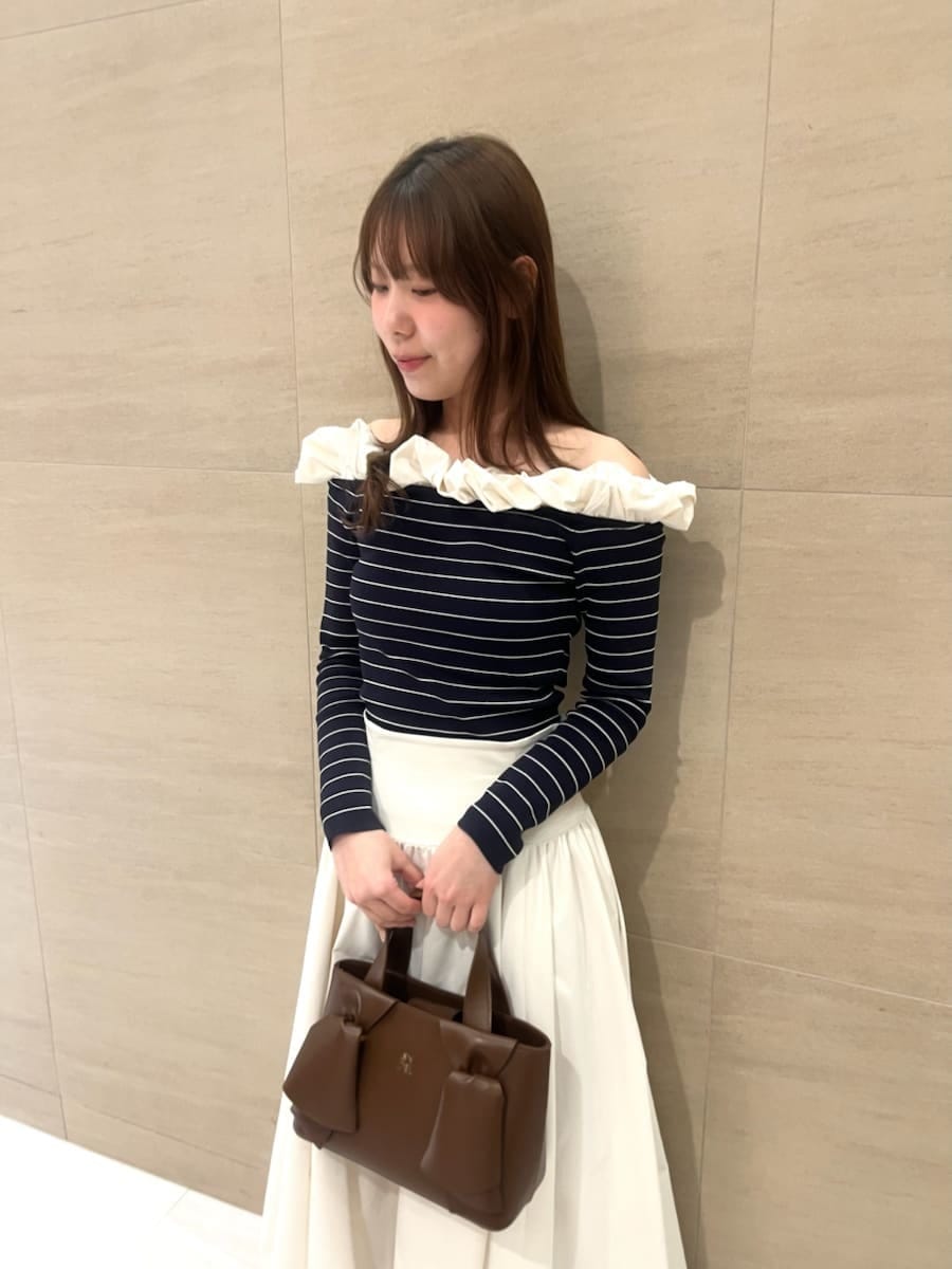 ブラック系のブーツ、ホワイト系のスカート、その他のニット/セーターを着用したレディースの冬コーディネートの4枚目の写真