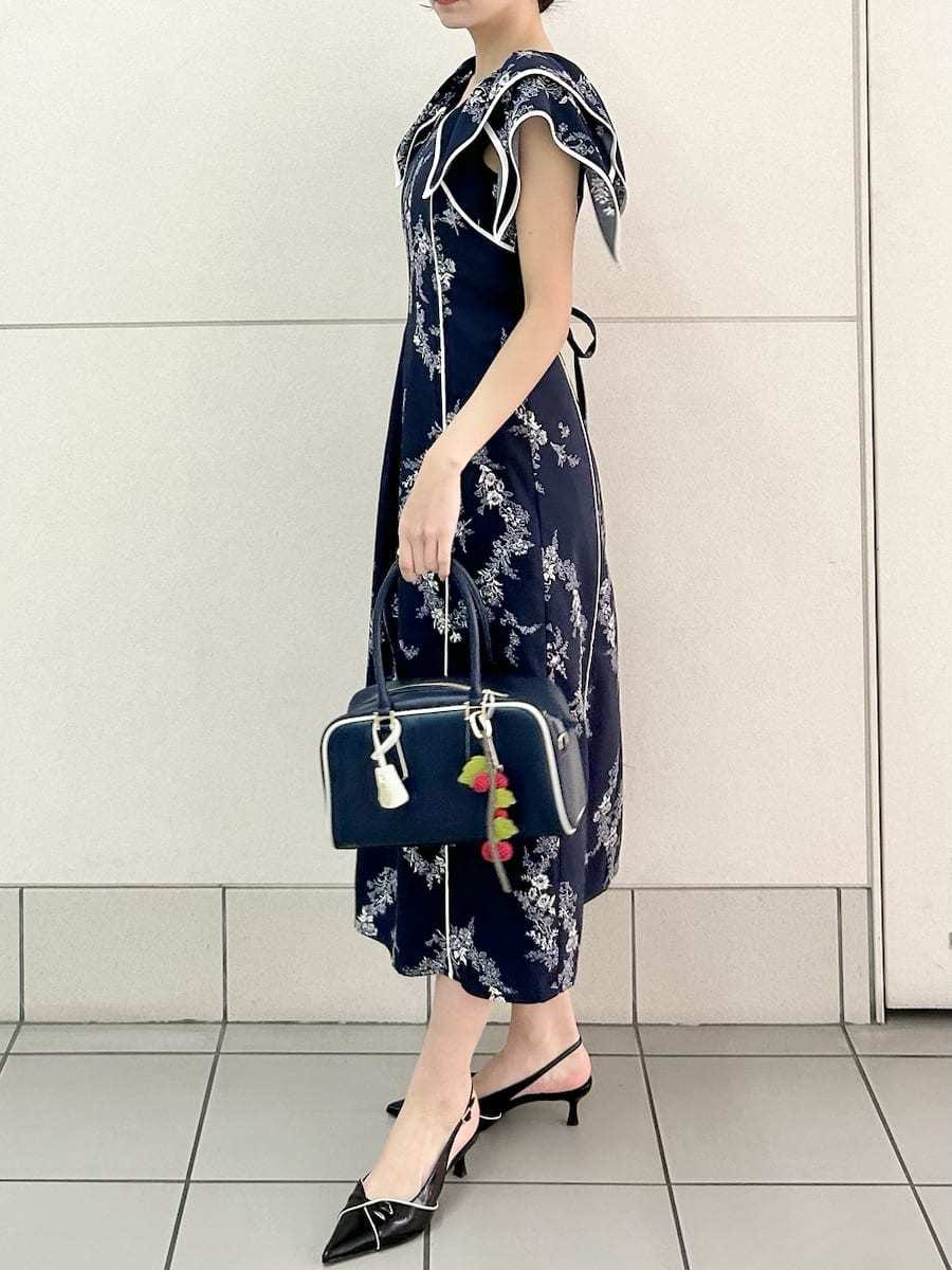 ブルー系のワンピース、ブラック系のパンプス、ブルー系のボストンバッグを着用したレディースの春コーディネートの4枚目の写真