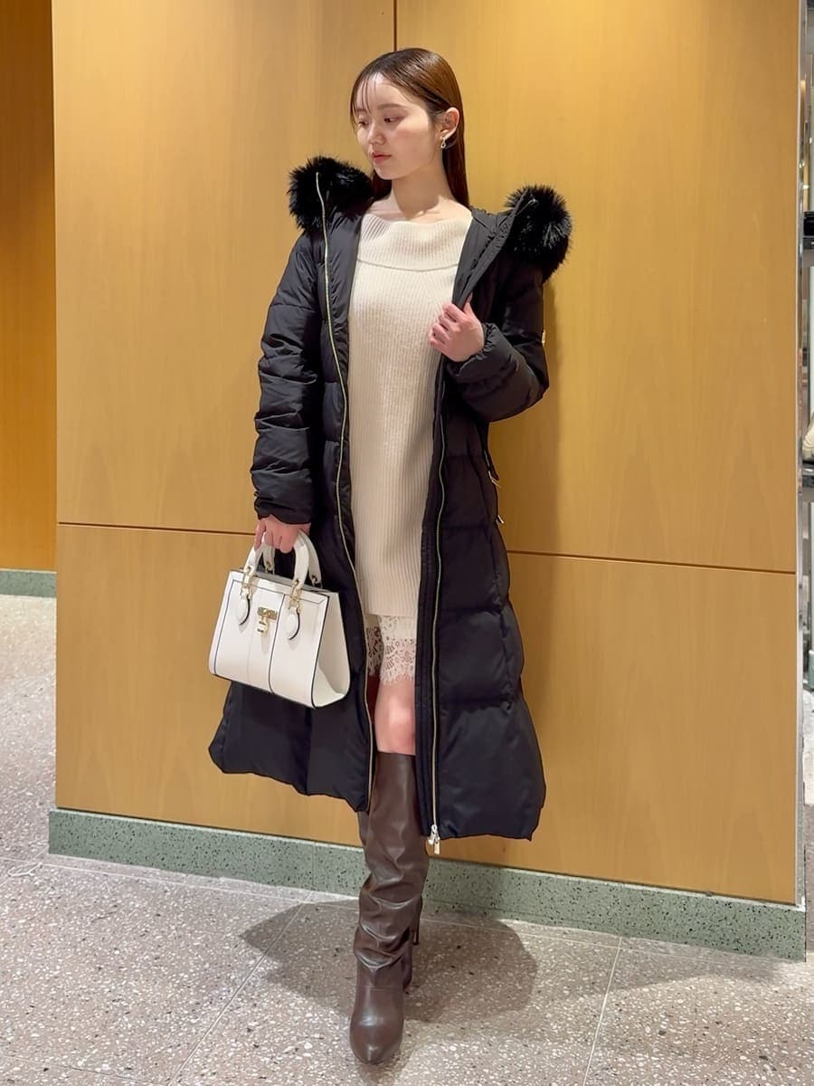 ホワイト系のワンピース、ブラック系のダウンジャケット/コート、ホワイト系のハンドバッグを着用したレディースの冬コーディネートの3枚目の写真