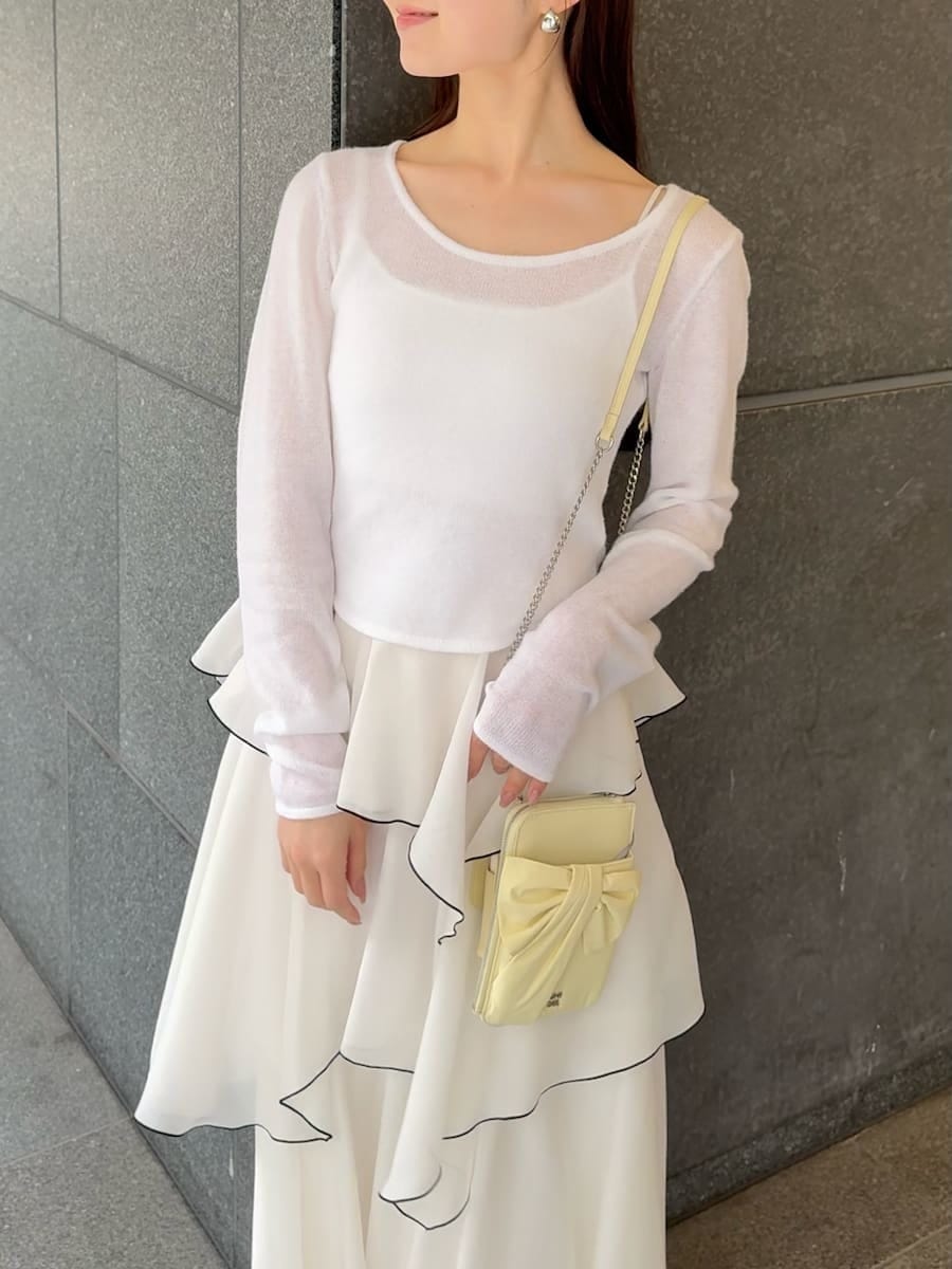 ホワイト系のワンピース、ブラック系のパンプス、イエロー系のショルダーバッグを着用したレディースの冬コーディネートの7枚目の写真